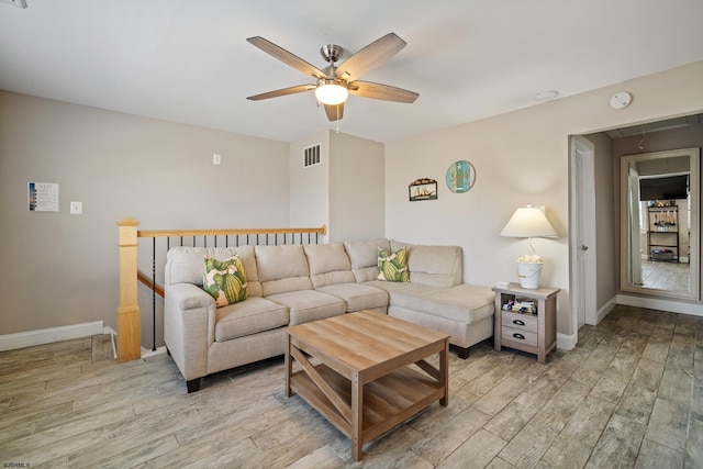 living room featuring light hardwood / wood-style flooring and ceiling fan