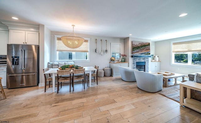 interior space with a tiled fireplace and light wood-type flooring