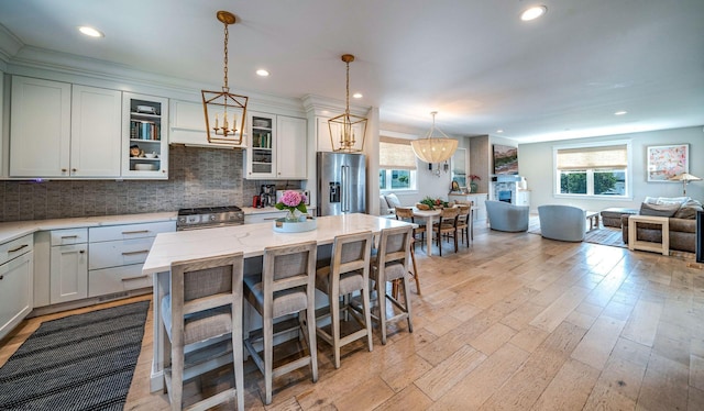 kitchen with high quality appliances, a breakfast bar, hanging light fixtures, and light stone countertops