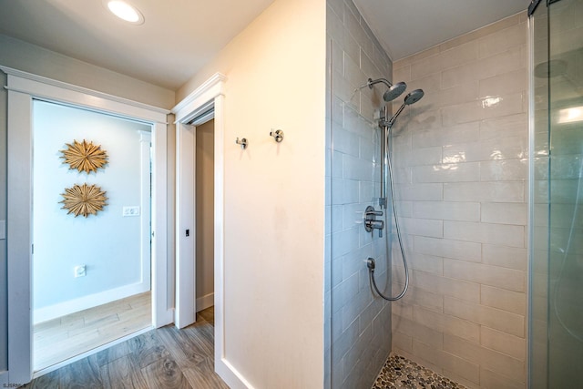 bathroom featuring a tile shower and hardwood / wood-style floors