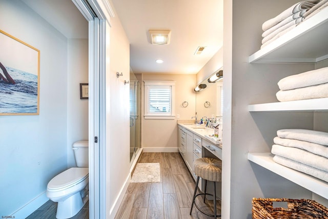 bathroom featuring an enclosed shower, wood-type flooring, vanity, and toilet