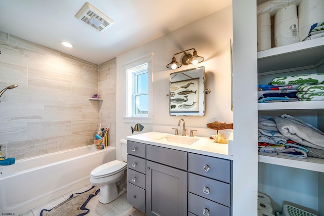 full bathroom with tile patterned flooring, tiled shower / bath, vanity, and toilet