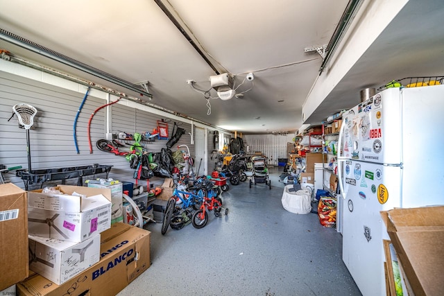 garage with a garage door opener and white fridge