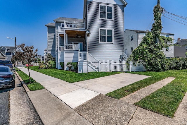 townhome / multi-family property with a balcony, covered porch, and a front lawn