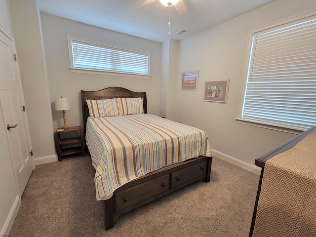 carpeted bedroom featuring visible vents, baseboards, and a ceiling fan