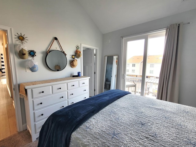 bedroom featuring access to exterior, lofted ceiling, and light wood-style flooring