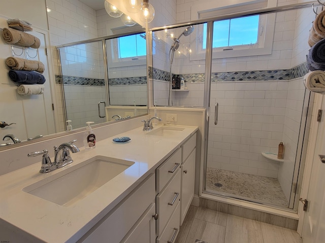 bathroom featuring double vanity, a sink, and a shower stall