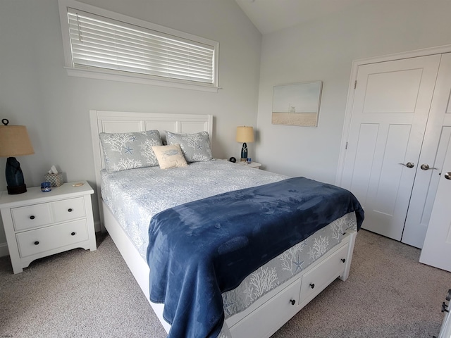 bedroom featuring lofted ceiling, a closet, and light colored carpet