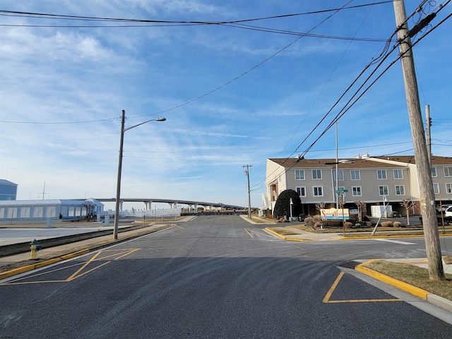 view of road featuring street lights, curbs, and sidewalks