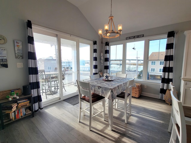 dining room featuring lofted ceiling, an inviting chandelier, and light wood-style flooring