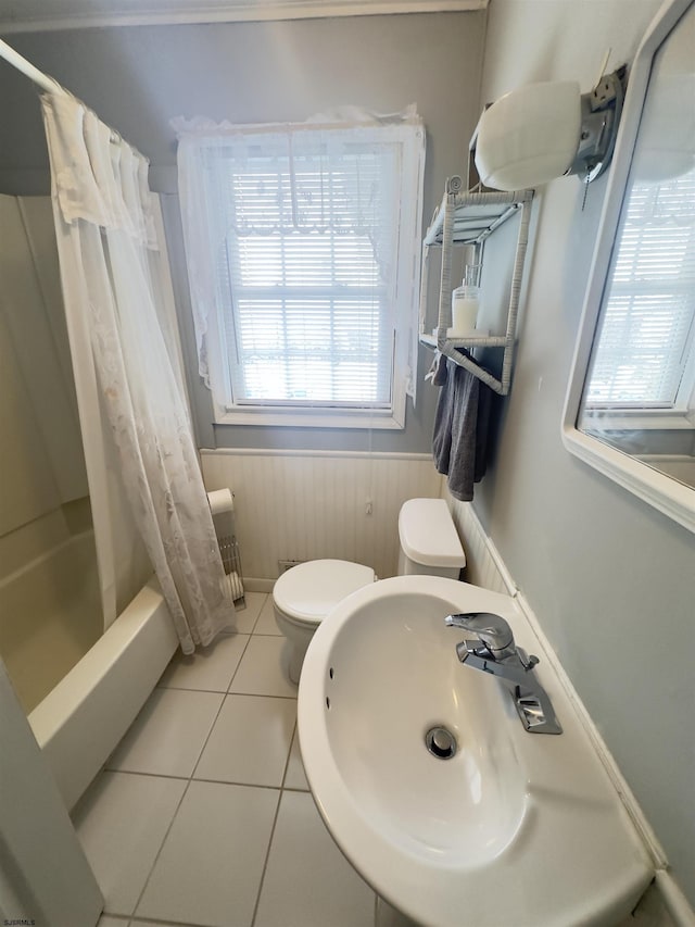 full bathroom featuring wooden walls, sink, toilet, tile patterned floors, and shower / bath combo with shower curtain