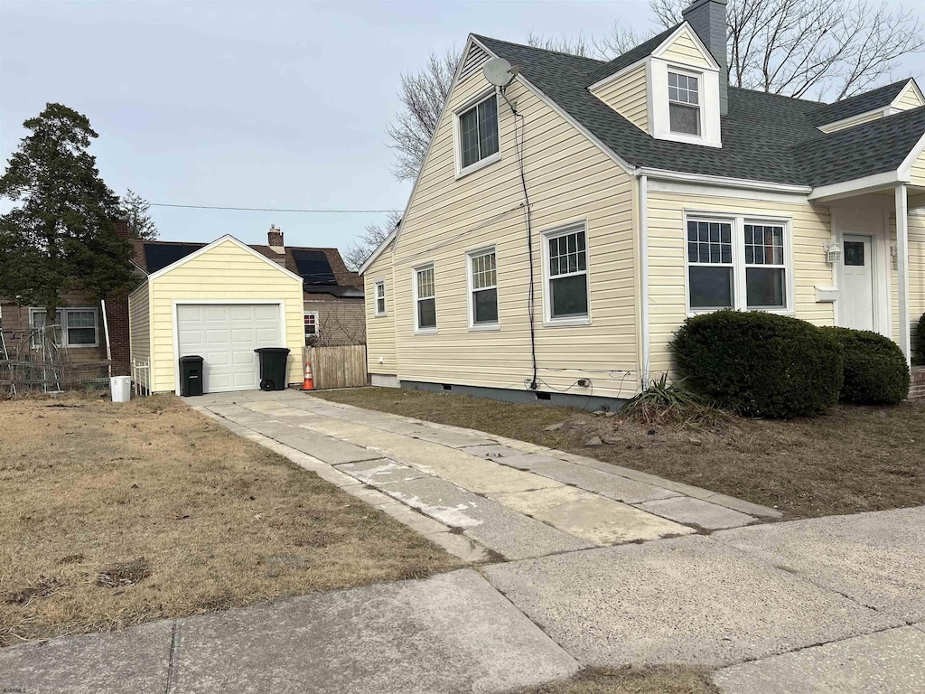 view of side of property with a garage and an outbuilding