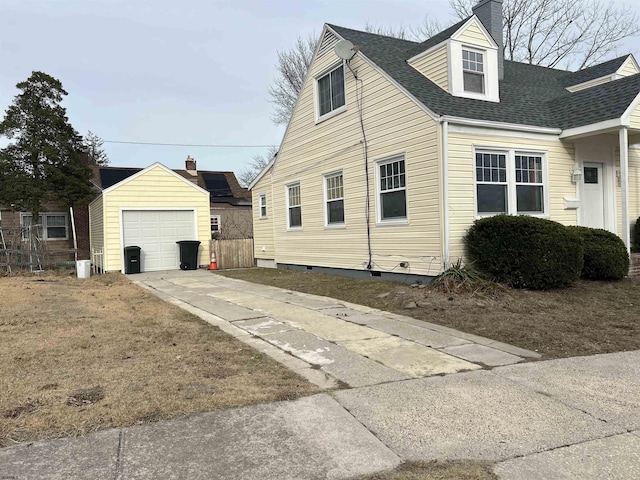 view of side of property with a garage and an outbuilding