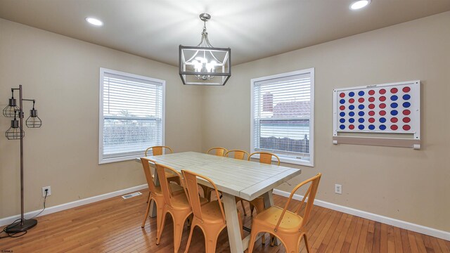 dining space featuring hardwood / wood-style floors, a notable chandelier, and a wealth of natural light