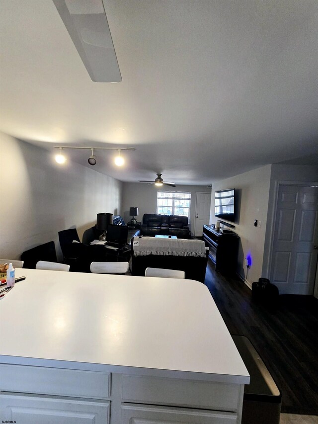 kitchen featuring white cabinetry, dark wood-type flooring, a center island, and ceiling fan