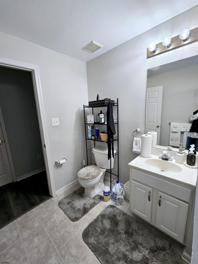 bathroom with tile patterned flooring, vanity, and toilet