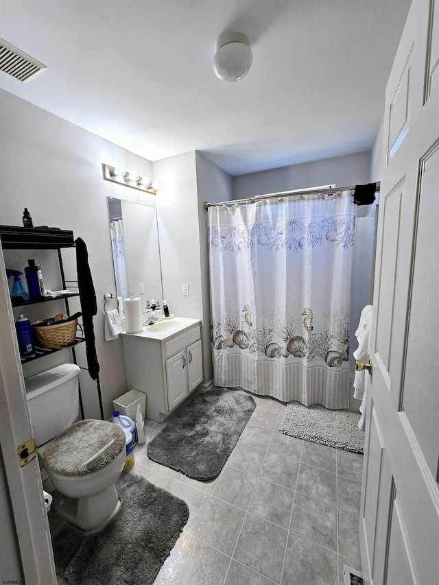 bathroom featuring tile patterned flooring, vanity, and toilet