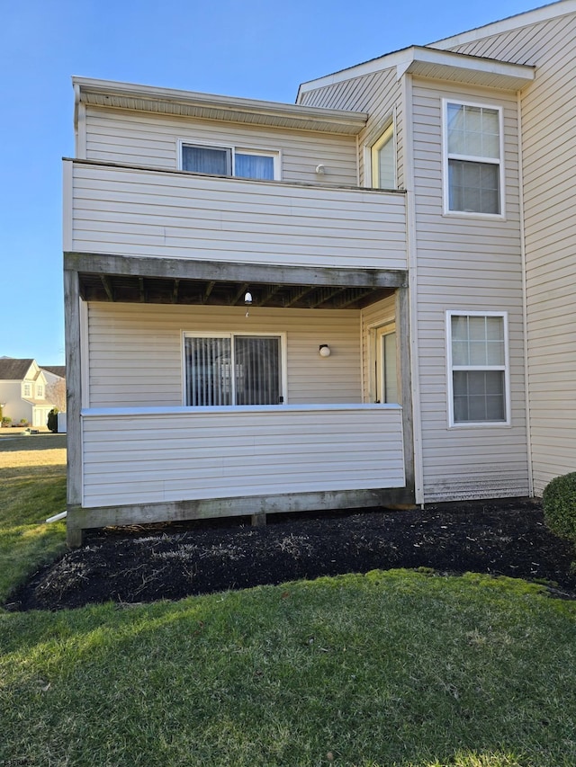 rear view of property with a lawn