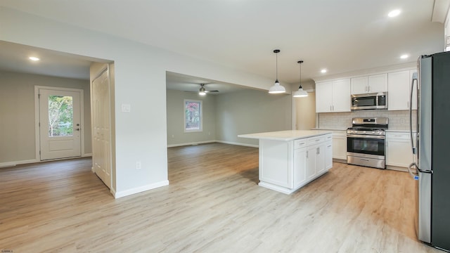 kitchen with pendant lighting, white cabinetry, backsplash, a center island, and stainless steel appliances