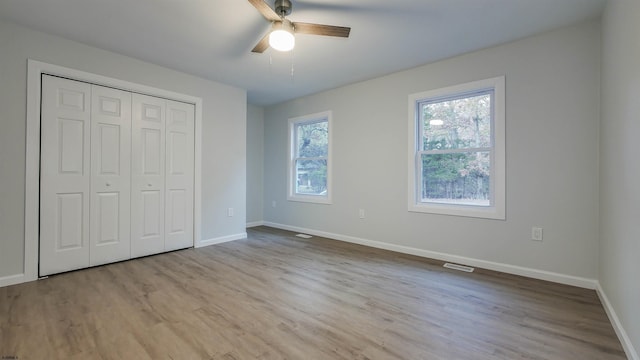 unfurnished bedroom with ceiling fan, light hardwood / wood-style floors, and a closet