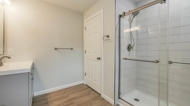 bathroom featuring hardwood / wood-style flooring, vanity, and walk in shower