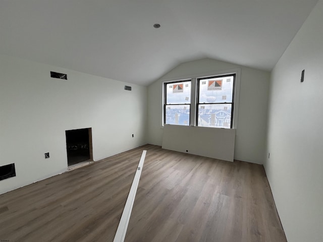 unfurnished living room with hardwood / wood-style flooring and vaulted ceiling