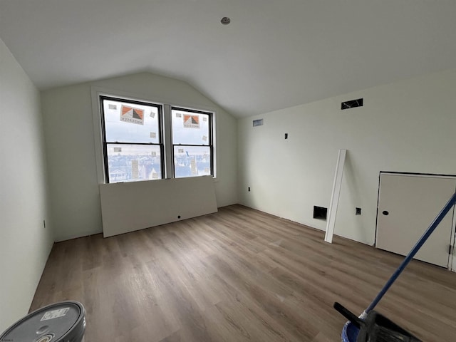 bonus room featuring vaulted ceiling and light hardwood / wood-style floors