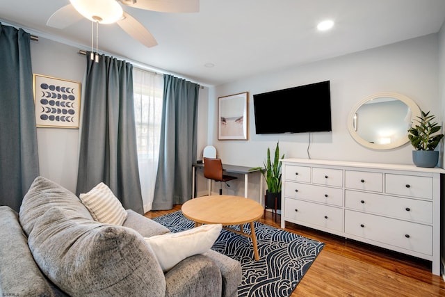 living room with wood-type flooring and ceiling fan