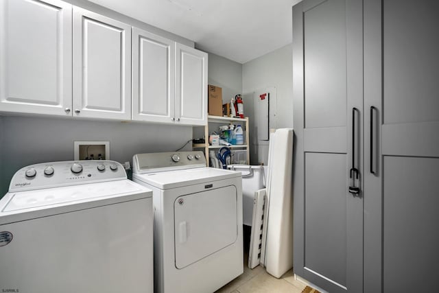 clothes washing area with cabinets, light tile patterned floors, and independent washer and dryer