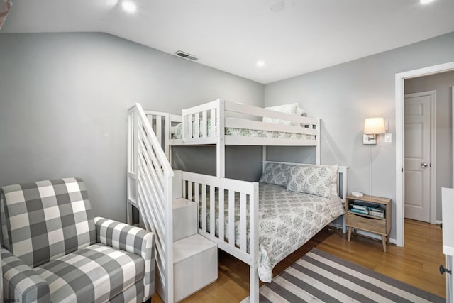 bedroom with vaulted ceiling and hardwood / wood-style floors