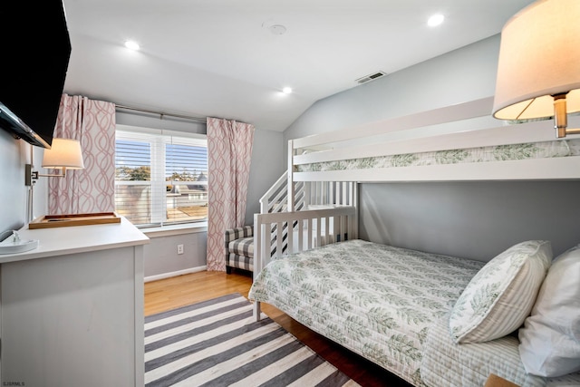 bedroom featuring lofted ceiling and light hardwood / wood-style floors