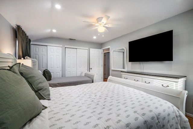 bedroom with multiple closets, ceiling fan, and vaulted ceiling