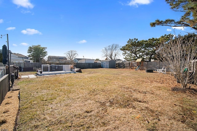 view of yard with a playground, a deck, and a storage shed