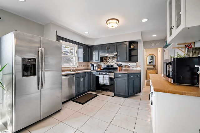 kitchen with sink, gray cabinetry, light tile patterned floors, appliances with stainless steel finishes, and backsplash