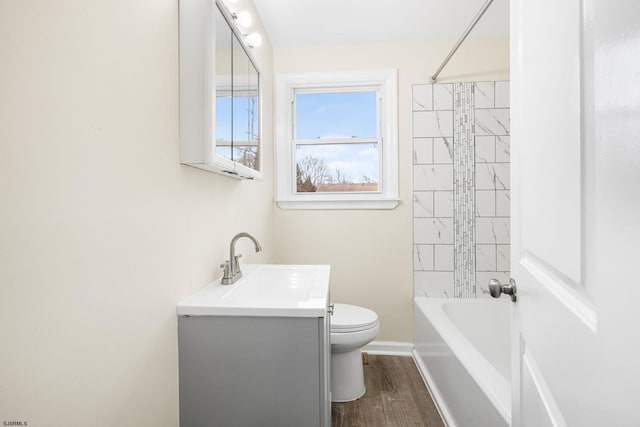 full bathroom featuring tiled shower / bath combo, vanity, wood-type flooring, and toilet