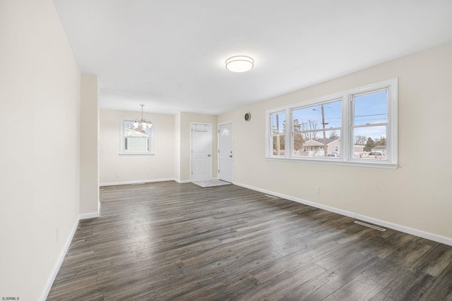 interior space featuring dark wood-type flooring and an inviting chandelier