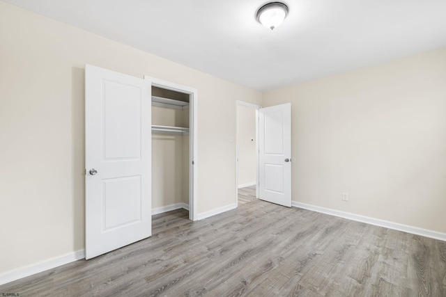 unfurnished bedroom featuring light hardwood / wood-style flooring and a closet