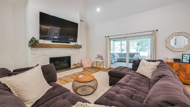 living room featuring hardwood / wood-style flooring, high vaulted ceiling, and a fireplace