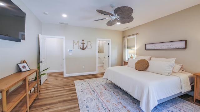 bedroom with ceiling fan, ensuite bath, and wood-type flooring