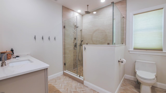 bathroom with an enclosed shower, vanity, parquet flooring, and toilet