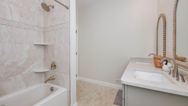 bathroom with tiled shower / bath combo and vanity