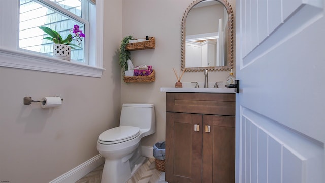 bathroom featuring vanity, parquet floors, and toilet