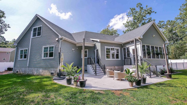 back of property with a yard and a patio area