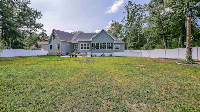 rear view of house featuring a yard and a patio area