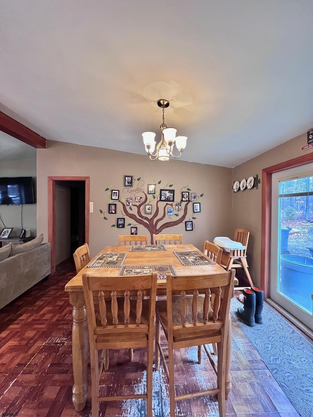 dining area with dark parquet flooring and a chandelier