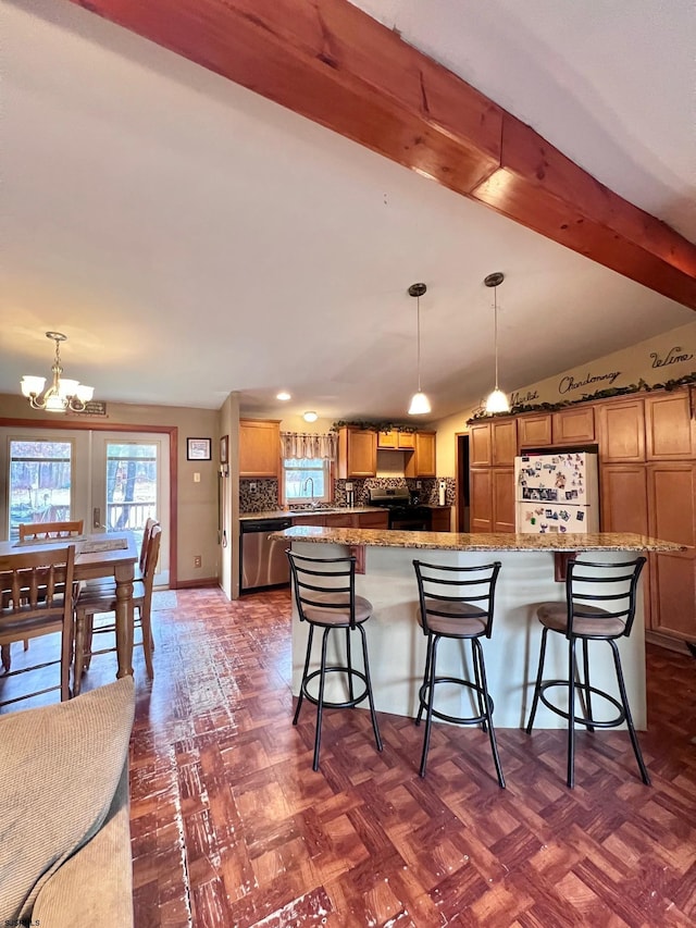 kitchen featuring beamed ceiling, appliances with stainless steel finishes, a breakfast bar area, and hanging light fixtures