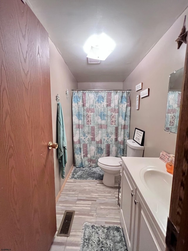 bathroom featuring vanity, walk in shower, and toilet