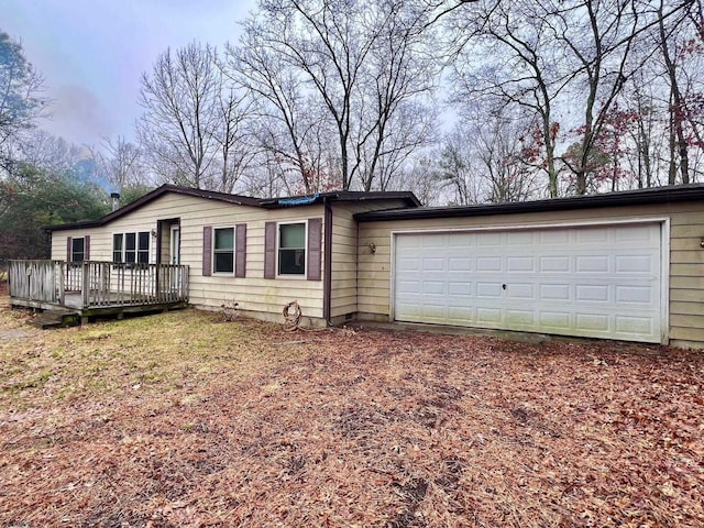 single story home featuring a wooden deck and a garage