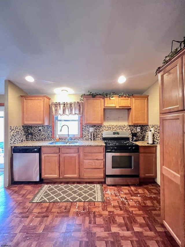 kitchen with stainless steel appliances, sink, dark parquet floors, and decorative backsplash