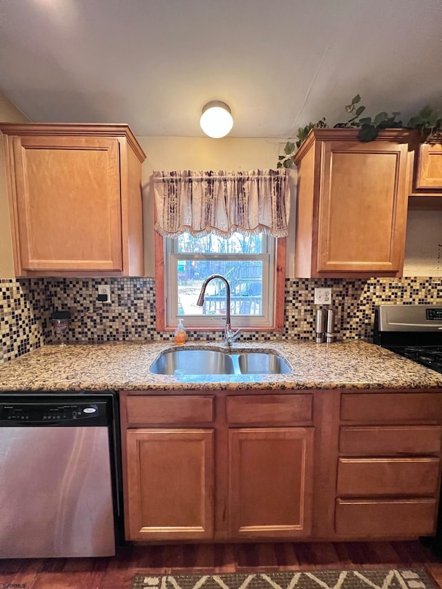 kitchen featuring appliances with stainless steel finishes, sink, backsplash, and light stone counters